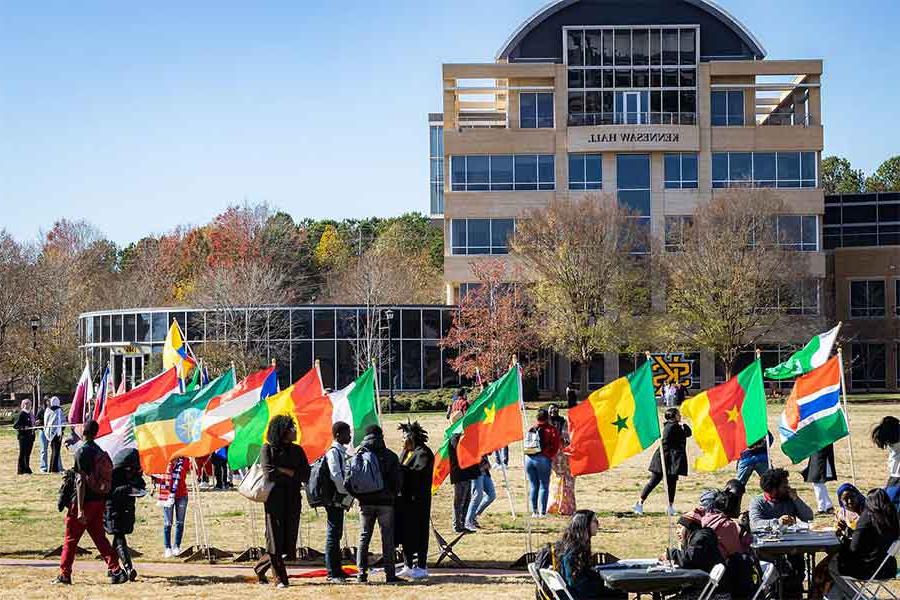学生们在校园绿地上举着全球国旗